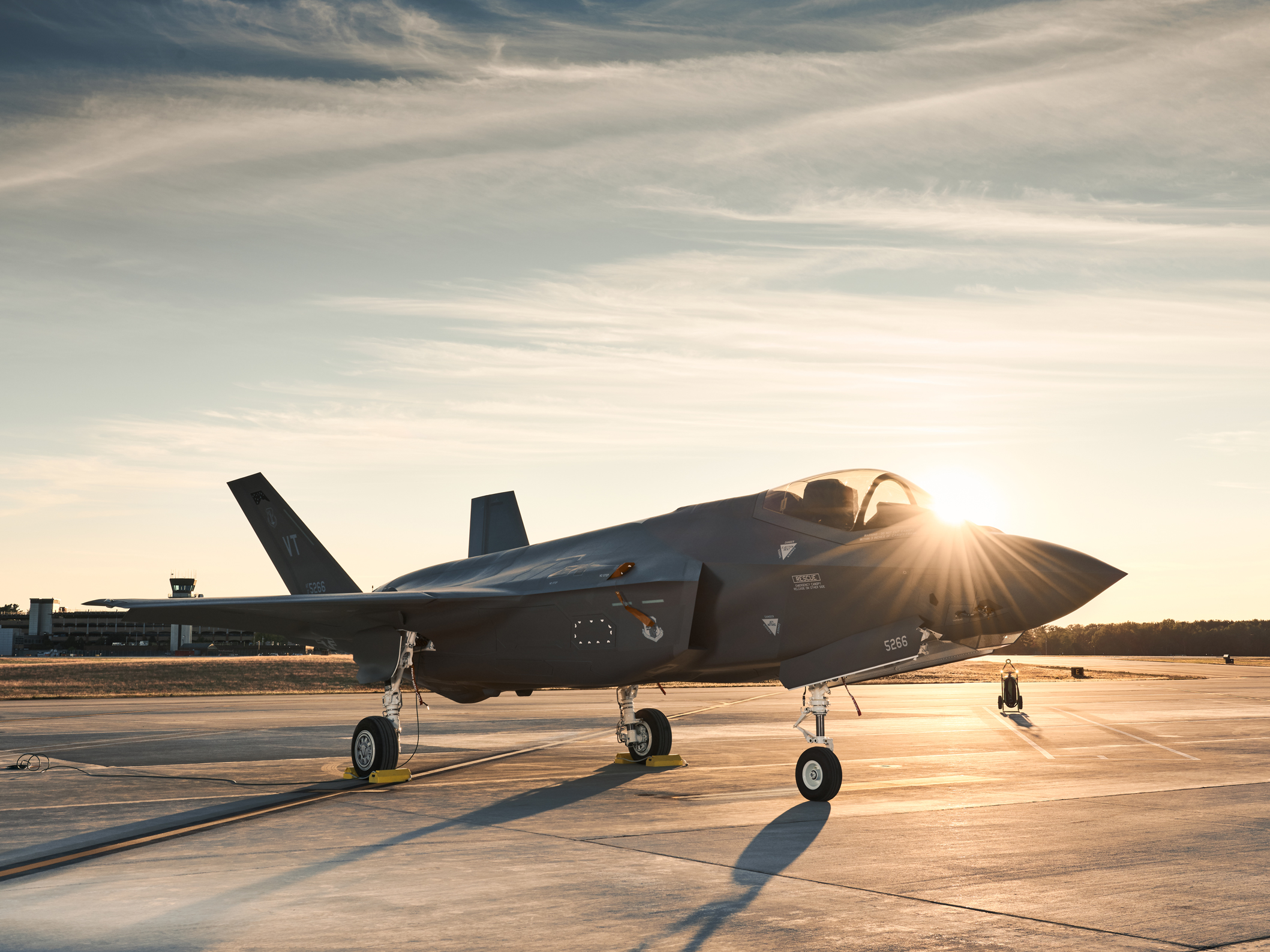 An F-35 sitting on the flight-line at sunset